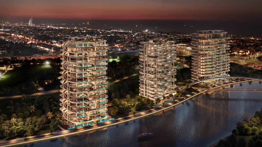 Casa AHS canal-front towers illuminated at night along the Dubai Water Canal with lit infinity pool terraces